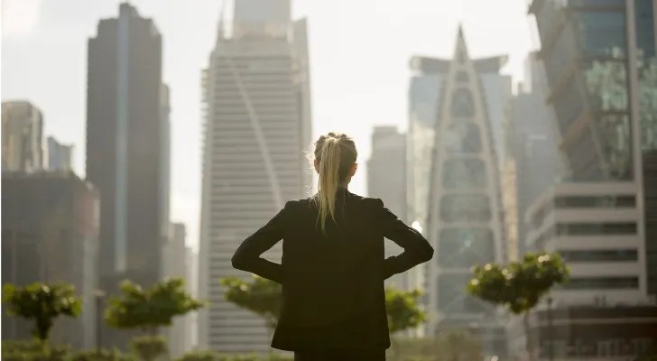 A real estate investor looks out over a city skyline.