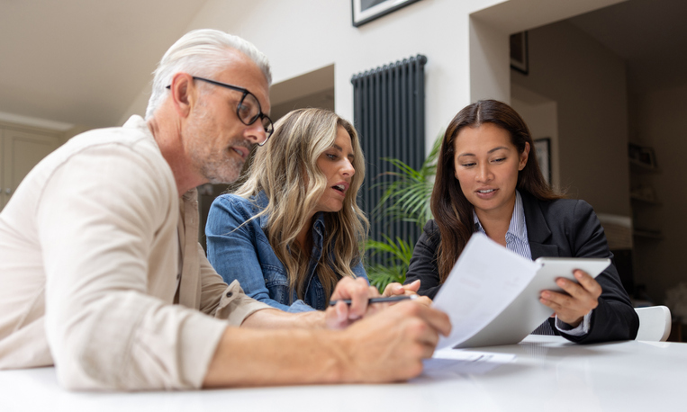 Financial advisor talking to a couple about their options to buy a house - home finances concepts