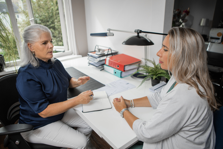 A woman meeting with a tax professional to discuss tax rules for an IRA rollover.